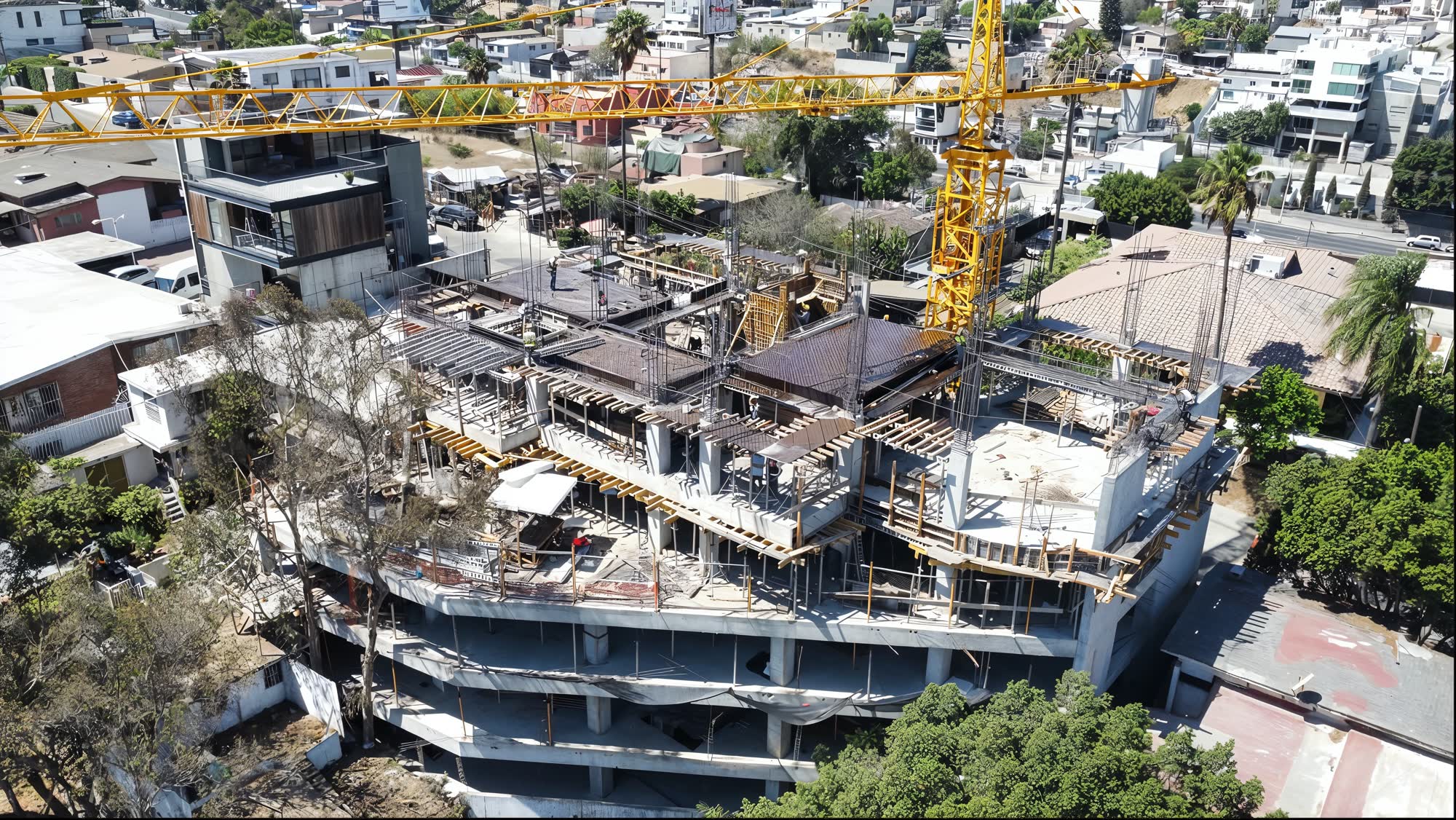 Avance de obra de Concord en agosto de 2026 — estructura de concreto, losas coladas y grúa torre sobre la calle General Ferreira, La Cacho, Tijuana